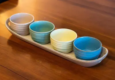 a tray filled with different colored bowls on a table at Welcoming Downtown Condo with WFH setup Balcony in Toronto
