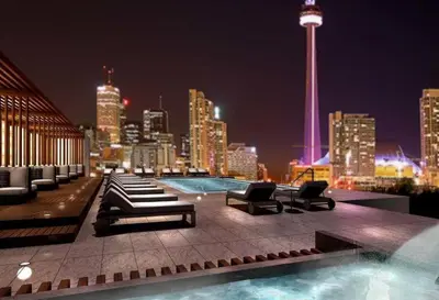 a rooftop pool with a view of a city at night at 3BR Rooftop Pool Gym Steps to MTCC and CN Tower with Parking in Toronto
