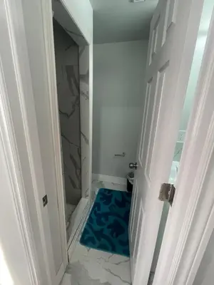a bathroom with a blue rug on the floor at Triple M Lodge Master Bedroom in Mississauga