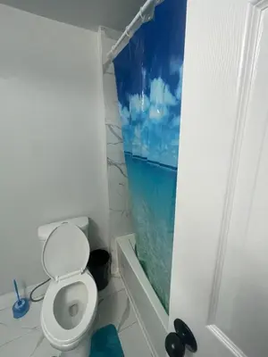 a bathroom with a toilet and a window at Triple M Lodge Double in Mississauga