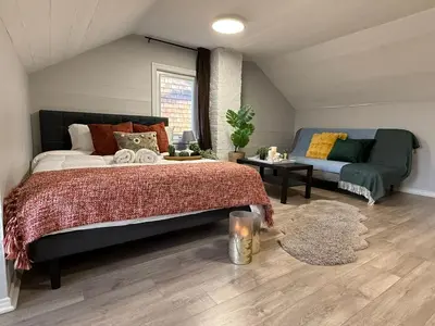 a bedroom with a bed and a couch at Family-Friendly 3BR in Little Italy in Toronto