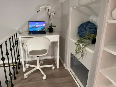 a desk with a laptop computer on a chair in a room at Family-Friendly 3BR in Little Italy in Toronto