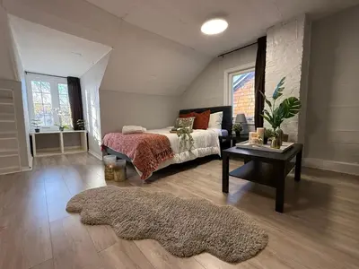 a bedroom with a bed and a table with a rug at Family-Friendly 3BR in Little Italy in Toronto