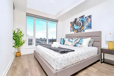 a bedroom with a large bed and a window at Luxurious 1BR Condo - Stunning City Views in Kitchener