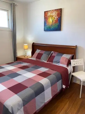 a bedroom with a bed with a plaid comforter at Lucky home- Vacation Houses in Trenton