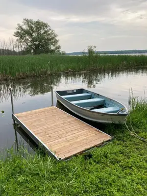 a blue boat next to a dock on a lake at Lucky home- Vacation Houses in Trenton