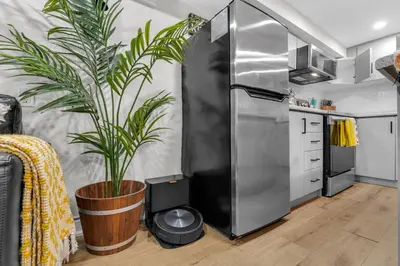 a kitchen with a large potted plant next to a refrigerator at Modern 2BR on Queensway, Kitchen, Parking, 20 Mins from CNT and YYZ in Toronto
