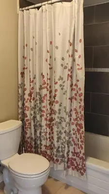 a bathroom with a toilet and a shower curtain at The Comfort Stay at City of Pickering in Pickering