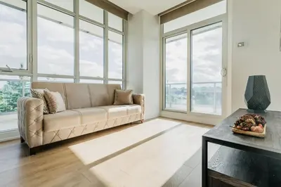 a living room with a couch and large windows at Cozy & Contemporary Suite - Easy Access to Everything in Richmond Hill