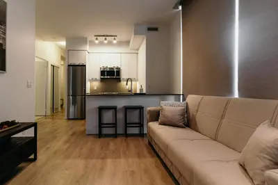 a living room with a couch and a kitchen at Cozy & Contemporary Suite - Easy Access to Everything in Richmond Hill