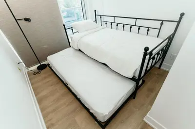two bunk beds in a small room with wood floors at Cozy & Contemporary Suite - Easy Access to Everything in Richmond Hill