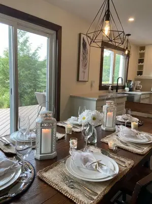 a dining room table with plates and glasses on it at Four Season Waterfront Muskoka Retreat in Bracebridge