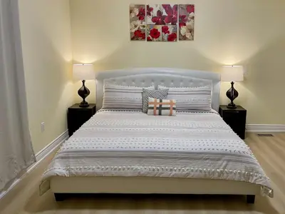 a bedroom with a large bed with two lamps at Victoria Family Vacation Home - King Bed Private Yard BBQ Deck Gazebo - 4 Minutes To The Falls in Niagara Falls