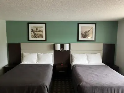 a hotel room with two beds and two pictures on the wall at Wellington Inn in Bracebridge