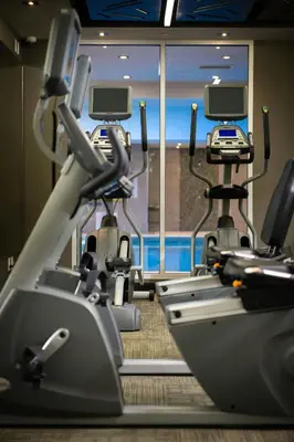 a gym with two cardio machines and a window at Delta Hotels by Marriott Waterloo in Waterloo