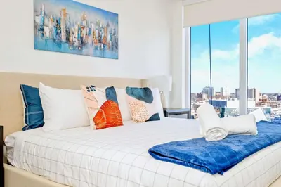 a bedroom with a large bed with a large window at Union Towers Condo with City Views and Patio in Kitchener
