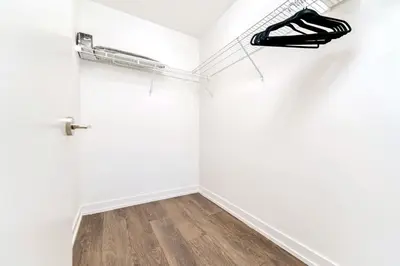 a room with a white wall with a shelf and shoes at Union Towers Condo with City Views and Patio in Kitchener