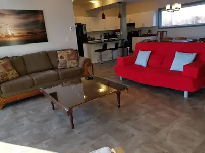 a living room with two couches and a red couch at SkyTime Vacations in Wellington