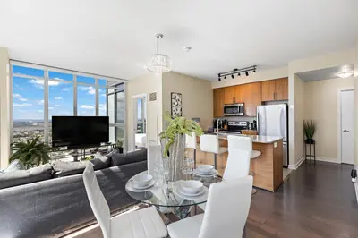 a living room with a couch and a table at Ultra Luxurious 2.5 Bedroom 2 Full Bathroom 1 Parking Condo Near SQ1 Striking Views in Mississauga