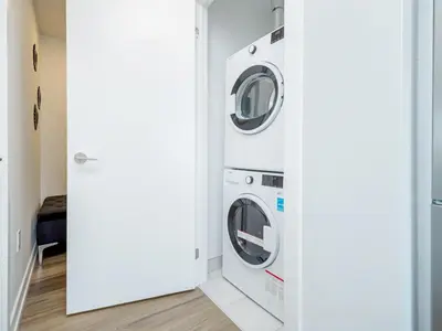 a laundry room with two washer and dryer at City View 1BR Condo - King Bed & Private Balcony in Kitchener