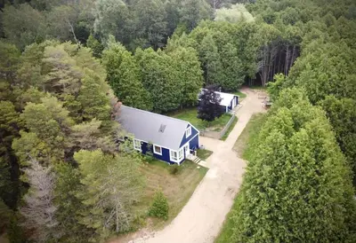 an aerial view of a blue and white rv in the woods at Cottage Retreat on 11 Acres in Flesherton