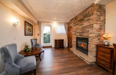 a living room with a fireplace and a table and chairs at Niagara Grandview Boutique Hotel in Niagara Falls