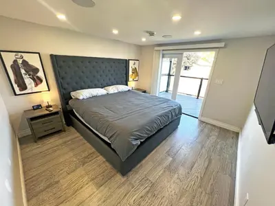 a bedroom with a bed with a headboard and a window at Luxe Home Near Limeridge - Sleeps 11 - Pool in Hamilton