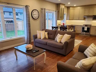 a living room with a couch and a table at 4 BD Family Retreat - Basement not Included in Stratford