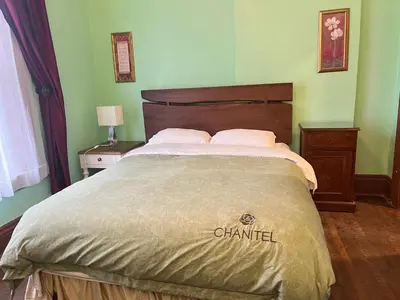 a bedroom with a bed with a chandan at THE RED STAR ROOM A in Niagara Falls