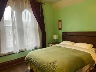 a bedroom with a large bed and a window at THE RED STAR ROOM A in Niagara Falls
