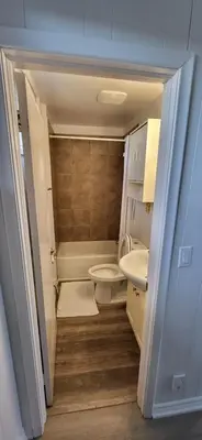a small bathroom with a toilet and a sink at Happyland Inn in Orillia