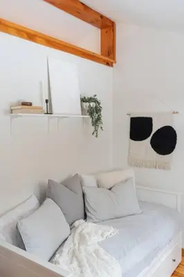 a white couch with pillows in a room at The Doma Lodge - Cozy Muskoka Cabin in the Woods in Huntsville