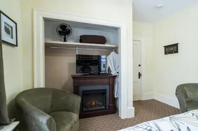 a living room with a fireplace and a chair at The Inn on Bay in Gravenhurst
