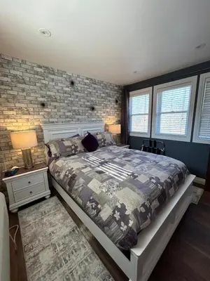 a bedroom with a bed and a brick wall at The Inn on Bay in Gravenhurst
