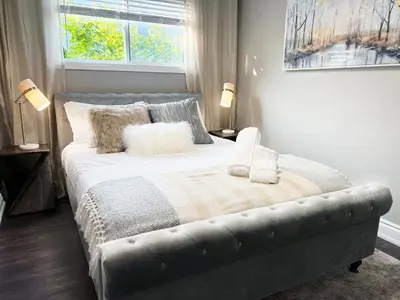 a bedroom with a bed with a blanket and a window at *NEW* Elegant Urban 2BR Retreat in London