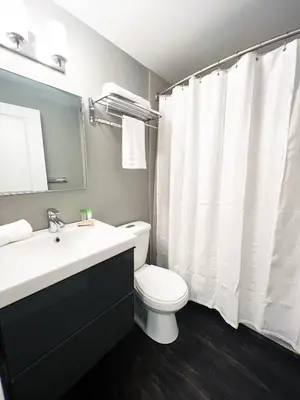 a bathroom with a white toilet and a sink at *NEW* Elegant Urban 2BR Retreat in London