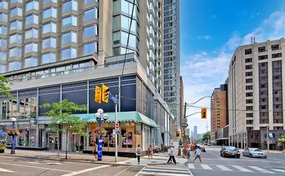 a busy city street with people crossing the street at University of Toronto UTSG Suites in Toronto