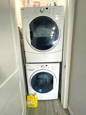 a washing machine is stacked on top of a door at Hamilton Haven - Smart Tech and BBQ Oasis - Pool in Hamilton