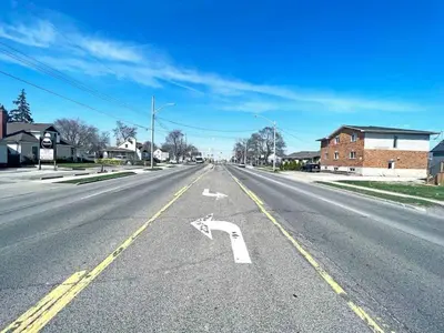 an empty street with an arrow on the road at Hamilton Haven - Smart Tech and BBQ Oasis - Pool in Hamilton
