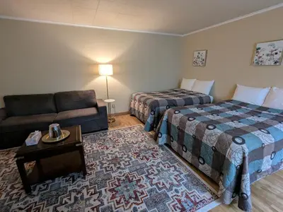 a hotel room with two beds and a couch at Mariner motor hotel in Collingwood