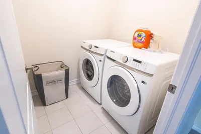 a laundry room with a washing machine and a washer at BRAND NEW home minutes from Niagara Falls. in Thorold