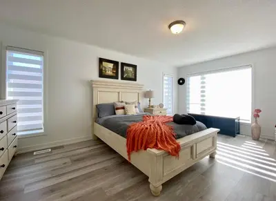 a bedroom with a bed with an orange blanket on it at 3 Bedroom Well-designed Townhouse in Whitby in Whitby