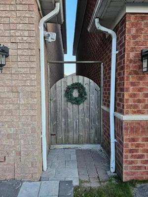 a gate to a brick building with a wreath on it at Poolside entire lower level apt in Whitby