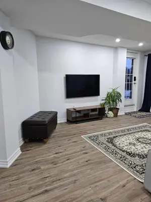 a living room with a flat screen tv on a wall at Poolside entire lower level apt in Whitby