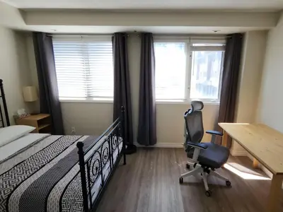 a bedroom with a bed and a desk and a chair at Scarborough Townhouse in Toronto