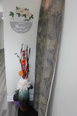 a stairway with a vase and a sign that reads home to our home at Comfy basement near KW airport in Kitchener