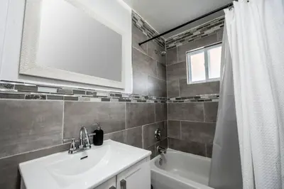a bathroom with a sink and a tub and a mirror at Luxury Stylish Home, Walk to Falls, Fire Pit&More in Niagara Falls