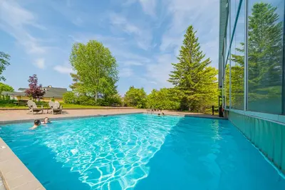 a swimming pool in a house with blue water at Horseshoe Valley Suites - The Aurora in Shanty Bay