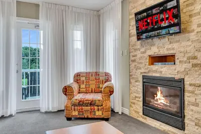 a living room with a chair and a fireplace at Cozy Getaway with Resort Perks in Edgar