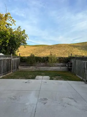 a backyard with a wooden fence and a field at Beautiful home in Mississauga